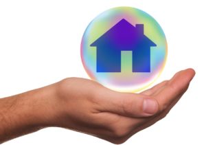 Picture of house in a bubble held by a hand.